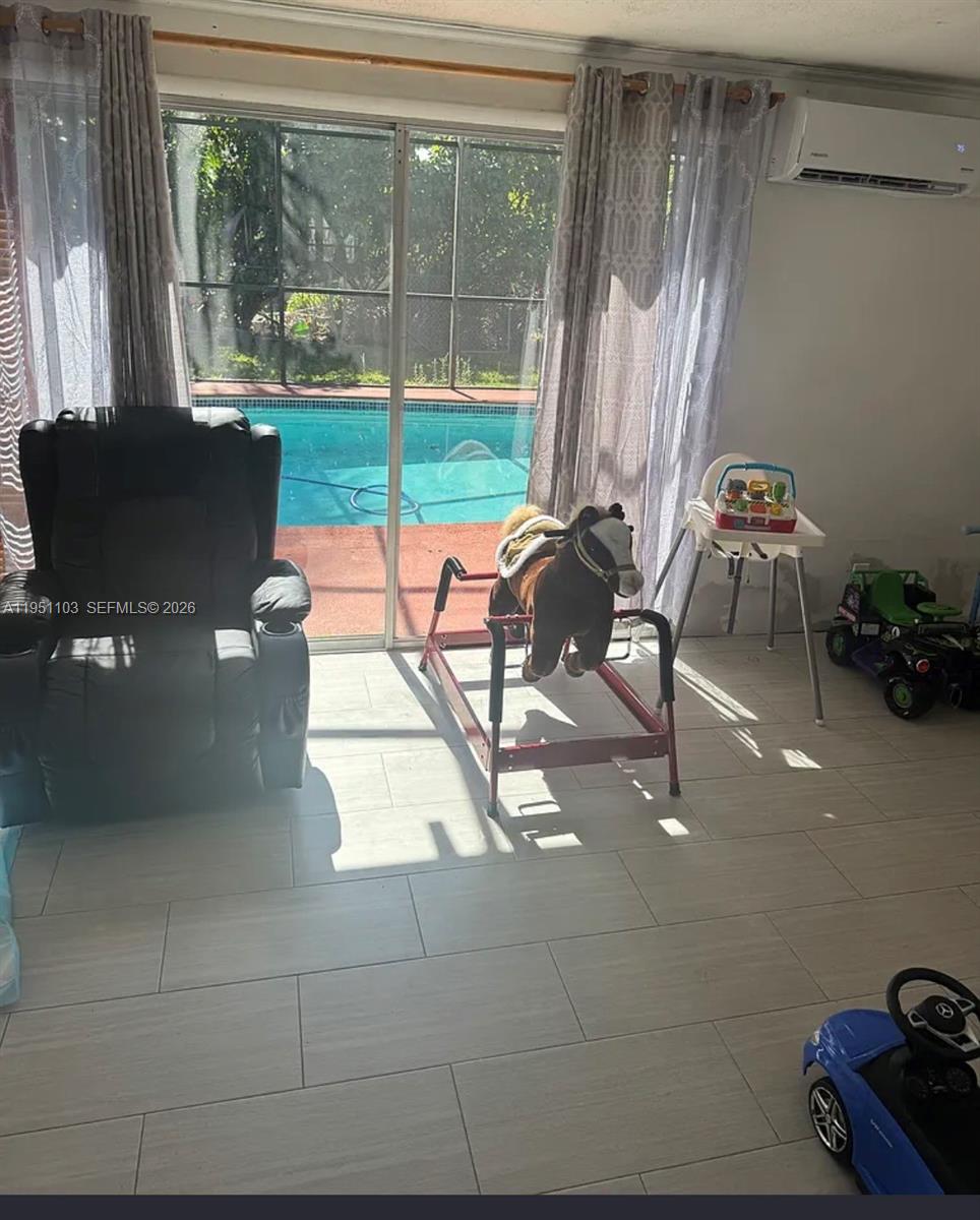 20530 Eagle Nest Road Cutler Bay, FL 33189 - Photo 8 of 17 a living room with patio furniture and a floor to ceiling window