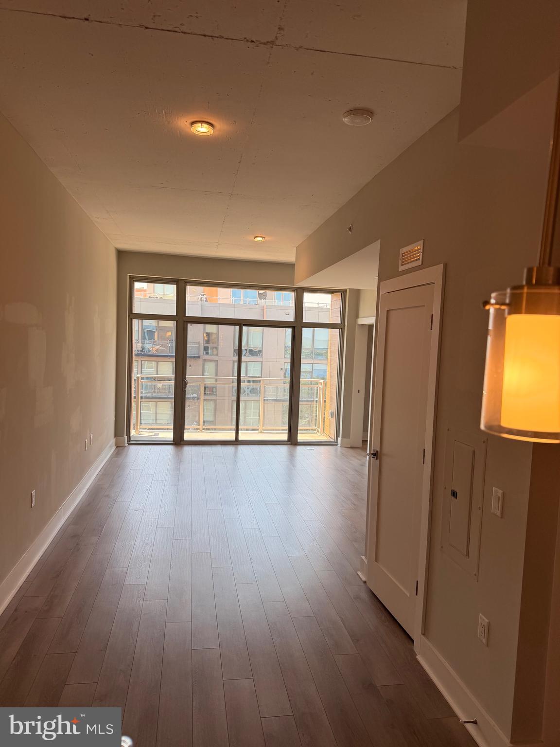 88 V Street Southwest, Unit 810 Washington, DC 20024 - Photo 11 of 14 an empty room with wooden floor and windows