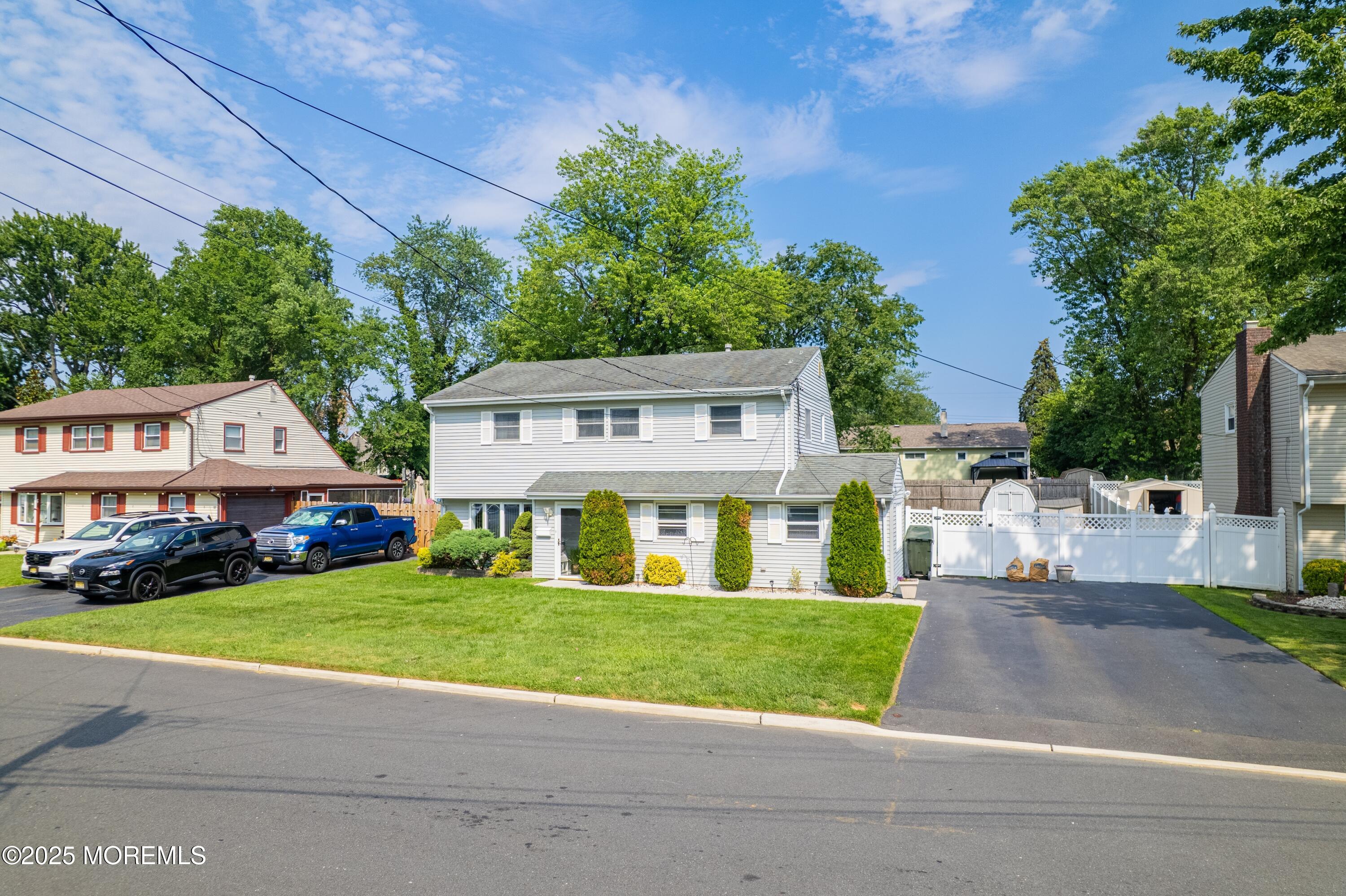 7 Carriage Road Hazlet, NJ 07730 - Photo 1 of 33 a view of a white house in front of a big yard with plants and large trees
