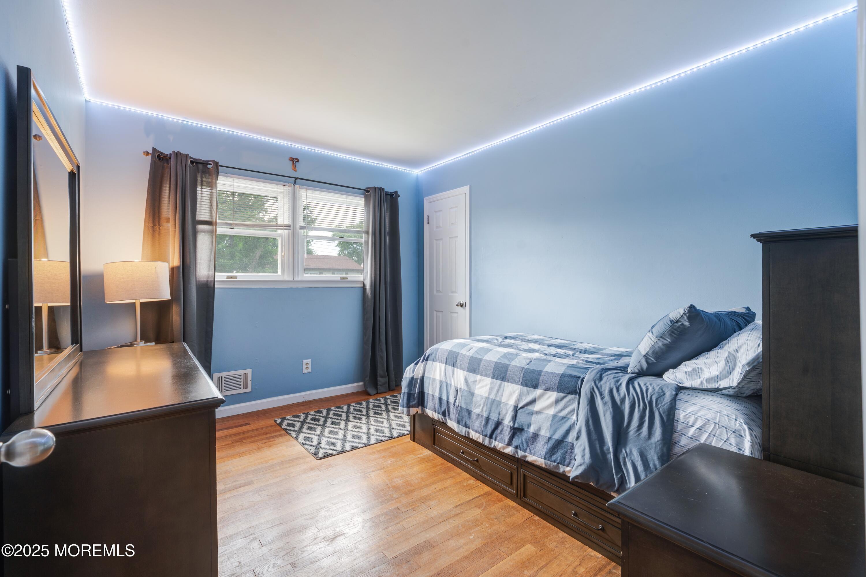 7 Carriage Road Hazlet, NJ 07730 - Photo 18 of 33 a bedroom with a bed and wooden floor