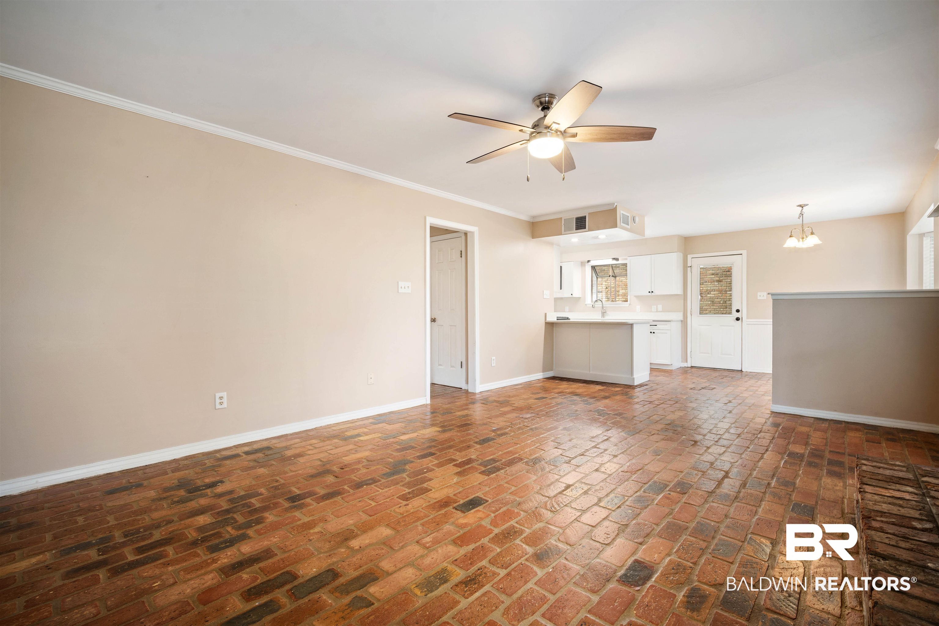 804 Wildwood Avenue Mobile, AL 36609 - Photo 7 of 30 Unfurnished living room with ceiling fan with notable chandelier, ornamental molding, and sink