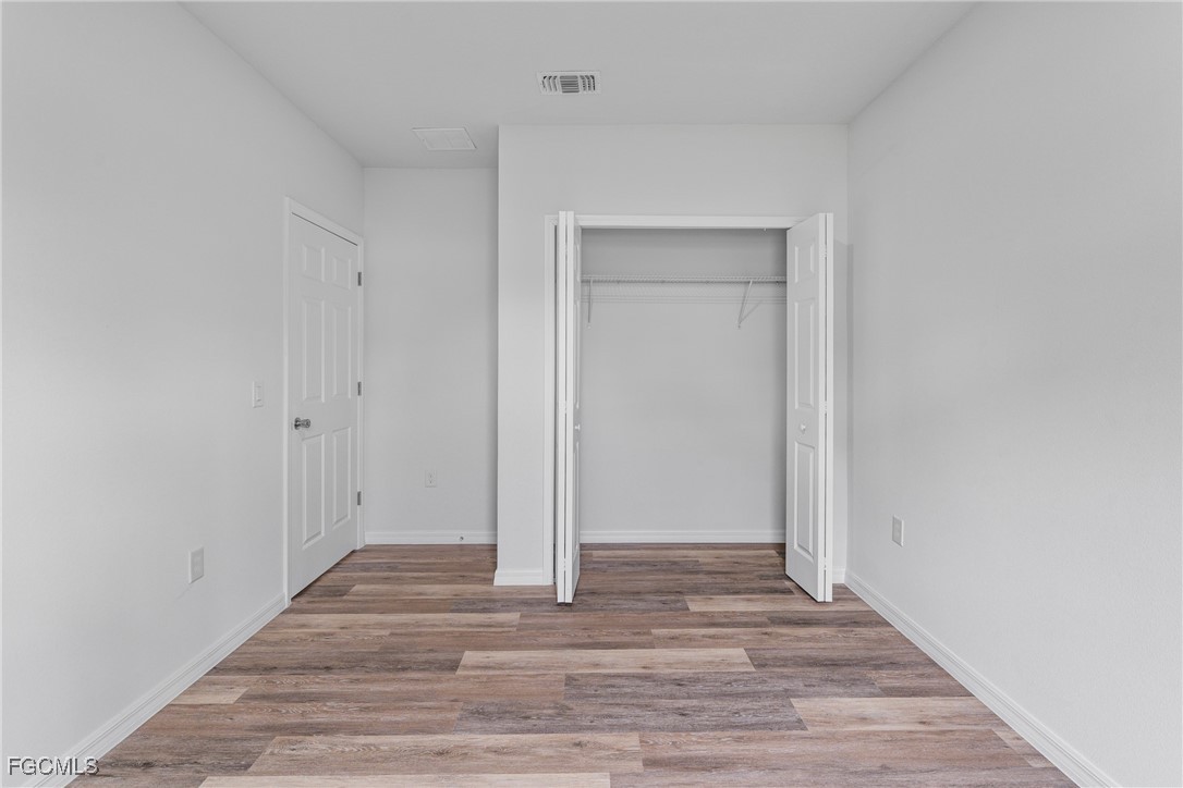 945 Butler Street East Lehigh Acres, FL 33974 - Photo 20 of 34 a view of an empty room with wooden floor