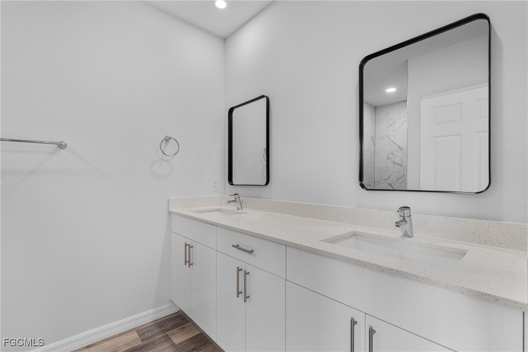 945 Butler Street East Lehigh Acres, FL 33974 - Photo 24 of 34 a bathroom with 2 sink and a mirror