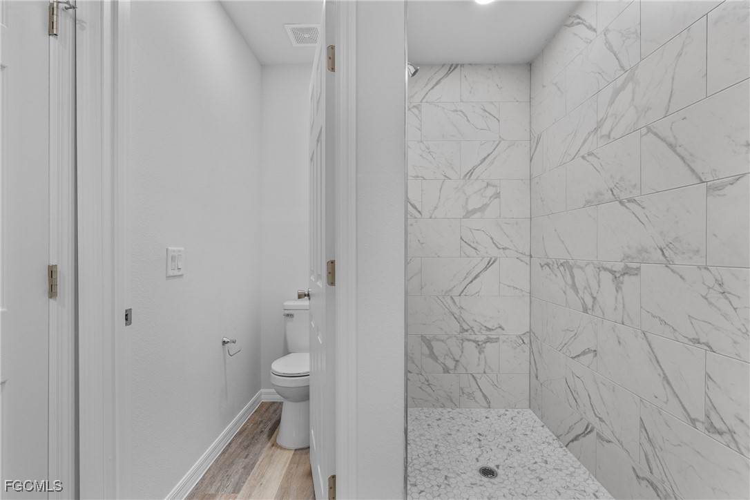 945 Butler Street East Lehigh Acres, FL 33974 - Photo 25 of 34 a bathroom with a shower and a toilet