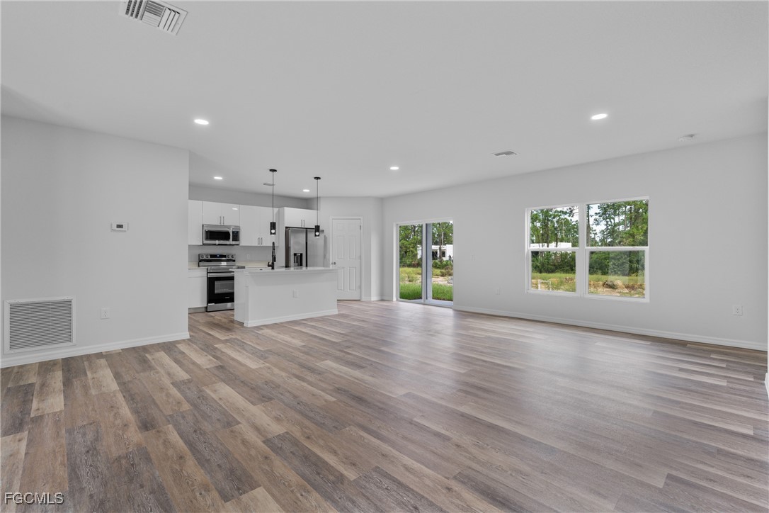 945 Butler Street East Lehigh Acres, FL 33974 - Photo 6 of 34 a view of empty room with kitchen and window