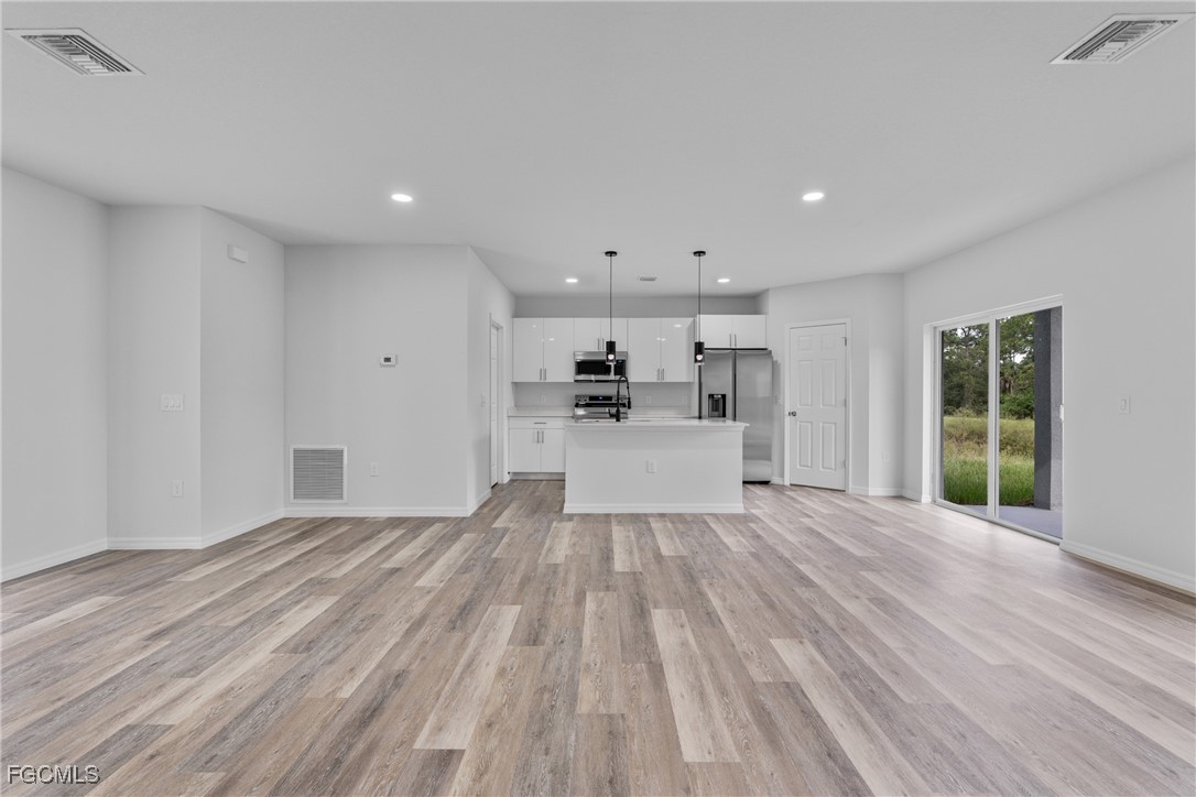 945 Butler Street East Lehigh Acres, FL 33974 - Photo 8 of 34 a view of a kitchen with wooden floor and windows