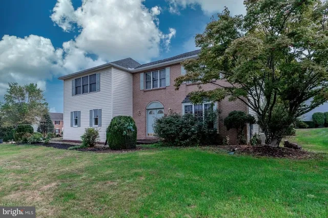 a view of a hallway with wooden floor a fireplace and a mirror