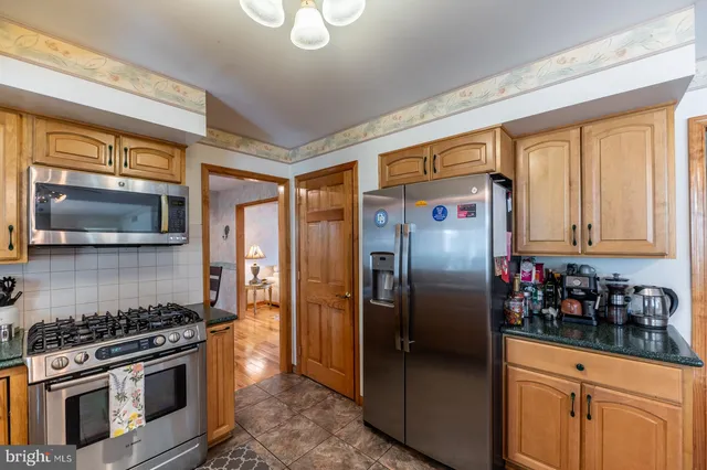 a large kitchen with stainless steel appliances granite countertop a sink and cabinets