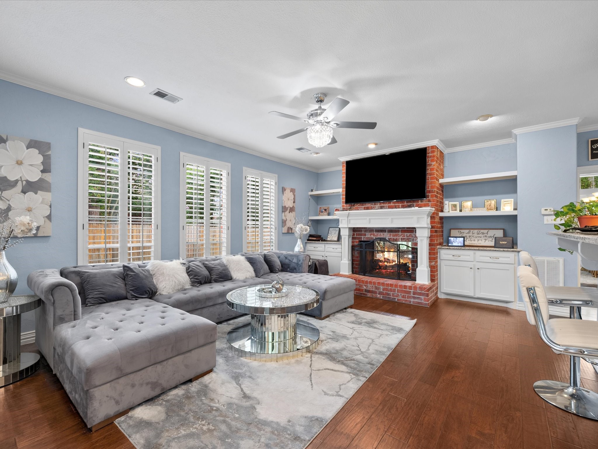 16123 Lafone Drive Spring, TX 77379 - Photo 17 of 47 Warm and inviting, the family room showcases rich wood flooring, a beautiful fireplace, custom built-ins, and walls of windows that fill the space with natural light.