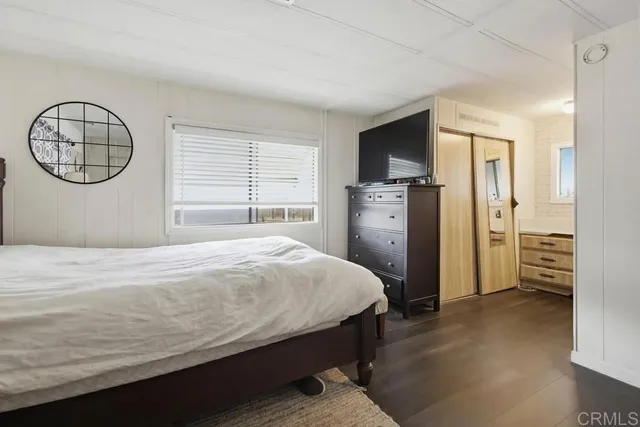 a bedroom with a bed a chandelier and dresser