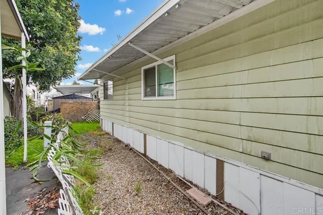 a yellow house with flower garden in front of it
