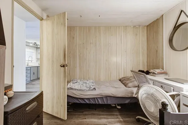 a bedroom with a bed and wooden floor