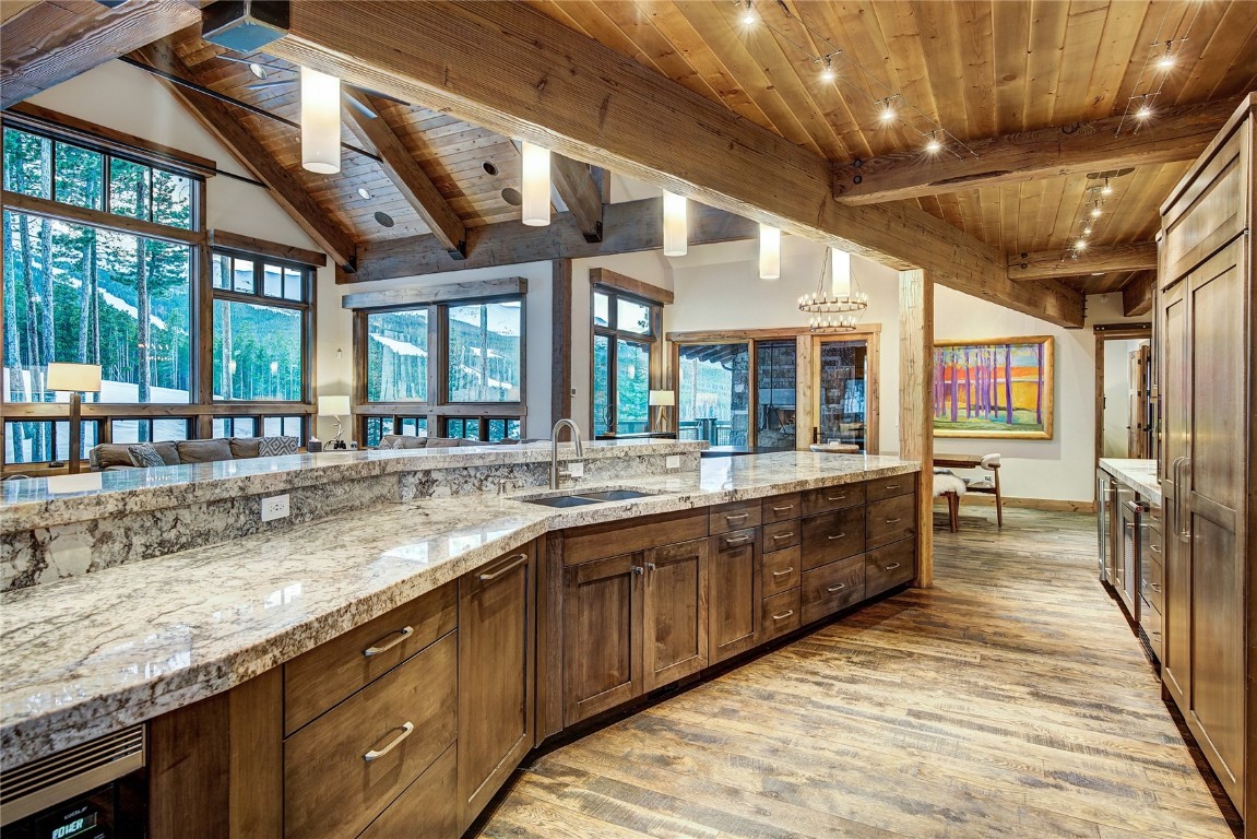 422 Timbertrail Road Breckenridge, CO 80424 - Photo 19 of 50 Kitchen featuring light stone counters, wood ceiling, light wood-style flooring, dark brown cabinetry, and dishwasher