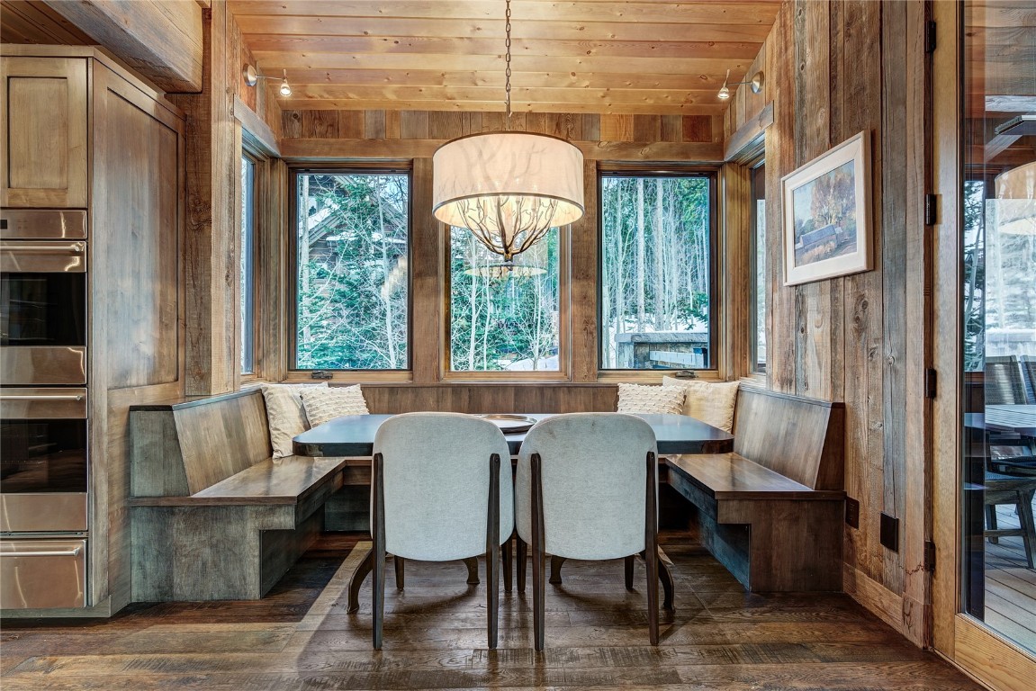 422 Timbertrail Road Breckenridge, CO 80424 - Photo 22 of 50 Dining room with wooden walls, wood ceiling, breakfast area, dark wood-style flooring, and plenty of natural light