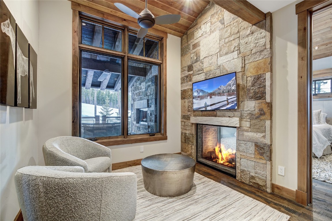 422 Timbertrail Road Breckenridge, CO 80424 - Photo 24 of 50 Living area featuring vaulted ceiling, wood finished floors, and a stone fireplace