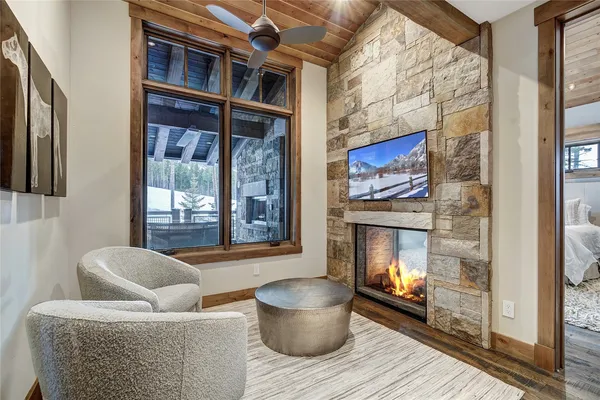 a living room with couches a fireplace and a flat screen tv