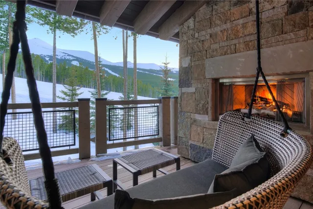 a living room with couches a fireplace and a large window