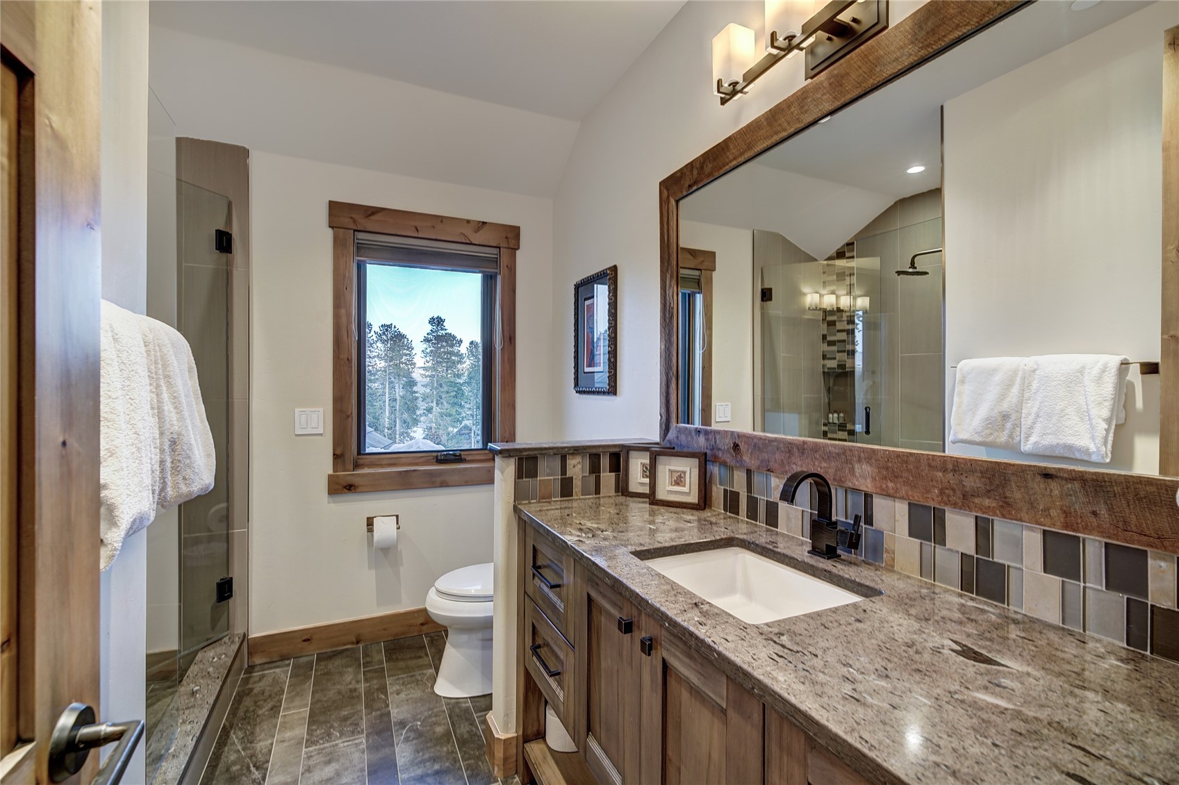 422 Timbertrail Road Breckenridge, CO 80424 - Photo 38 of 50 a bathroom with a granite countertop sink a toilet a mirror and shower