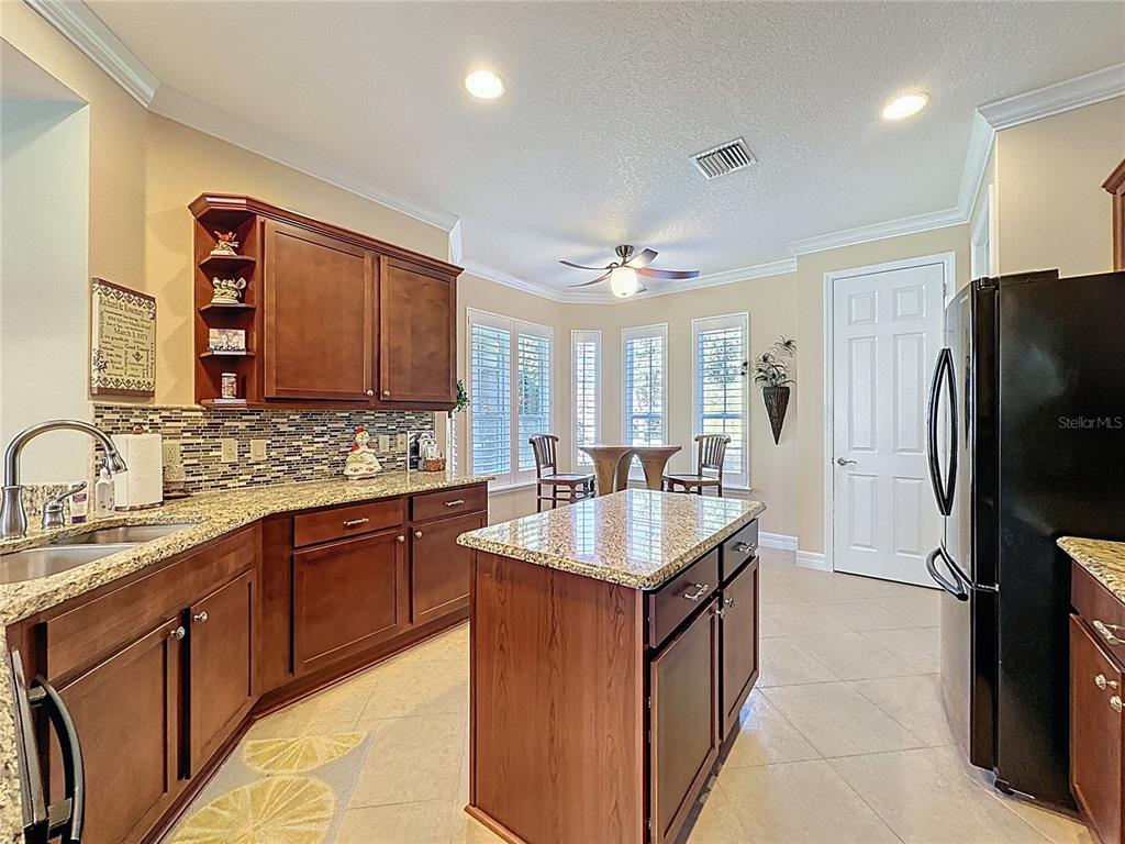 404 Silver Maple Road Groveland, FL 34736 - Photo 16 of 40 a kitchen with stainless steel appliances granite countertop a sink stove and refrigerator