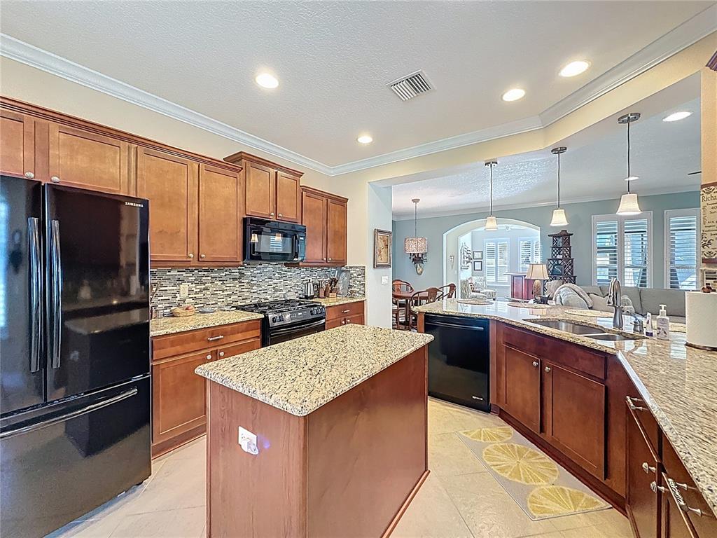 404 Silver Maple Road Groveland, FL 34736 - Photo 20 of 40 a kitchen with a refrigerator a sink and wooden cabinets