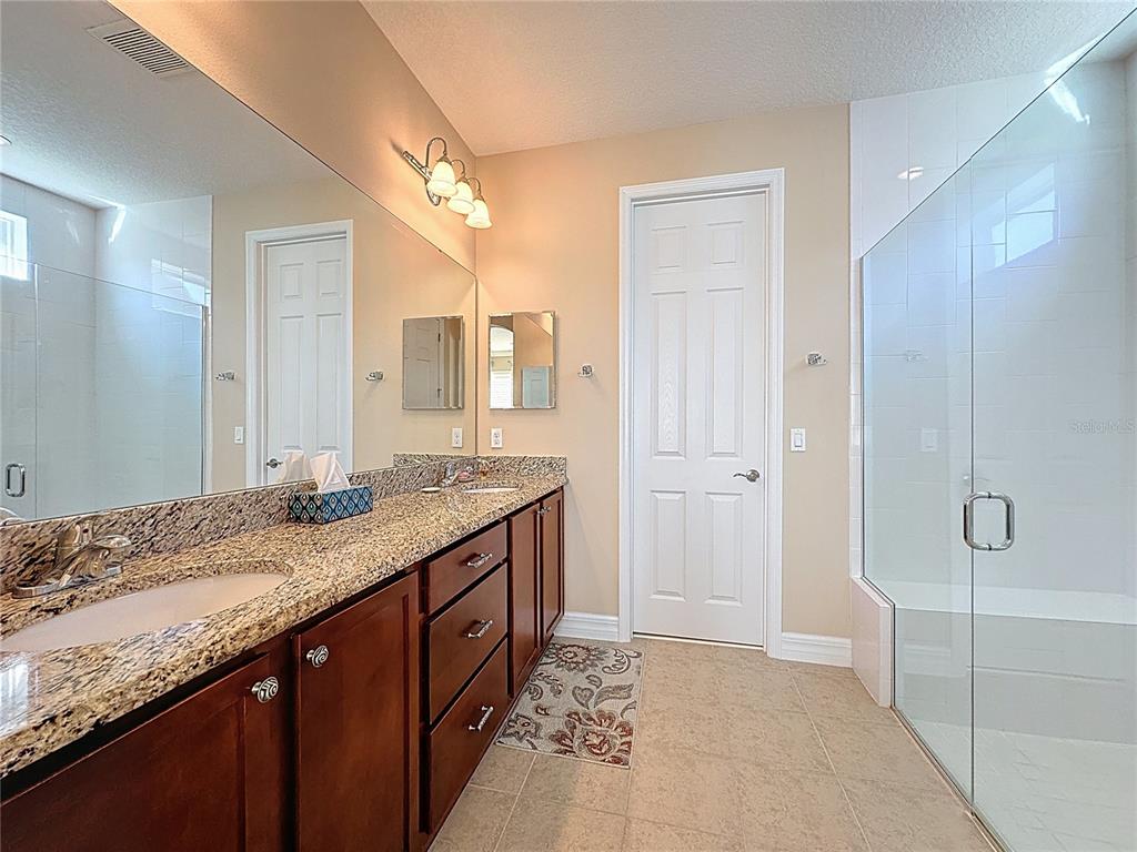 404 Silver Maple Road Groveland, FL 34736 - Photo 22 of 40 a bathroom with a granite countertop sink and a mirror