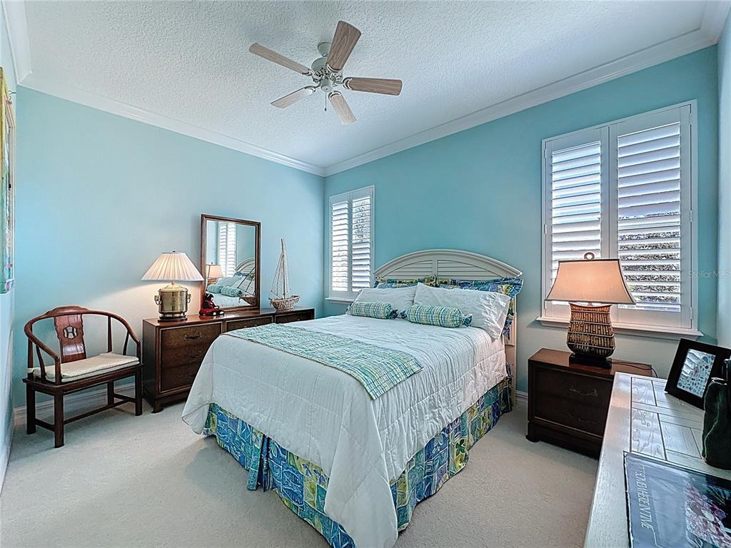 404 Silver Maple Road Groveland, FL 34736 - Photo 23 of 40 a spacious bedroom with a bed a couch and a chandelier