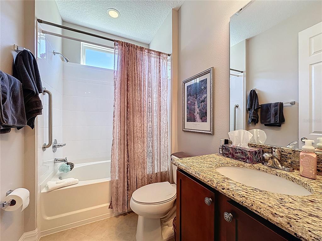 404 Silver Maple Road Groveland, FL 34736 - Photo 26 of 40 a bathroom with a granite countertop sink toilet and shower