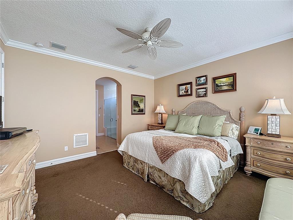404 Silver Maple Road Groveland, FL 34736 - Photo 29 of 40 a spacious bedroom with a bed and a ceiling fan