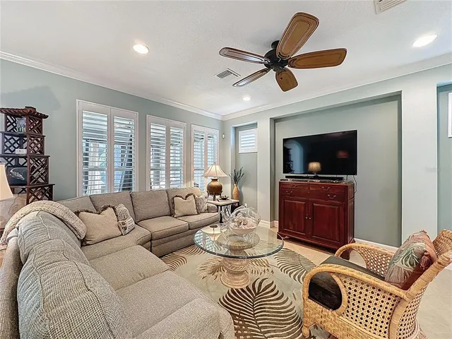 a living room with furniture a ceiling fan and a window