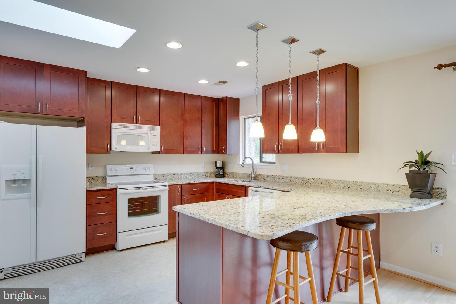 12348 Lima Lane Reston, VA 20191 - Photo 11 of 26 a kitchen with stainless steel appliances granite countertop wooden cabinets a stove a sink and a refrigerator