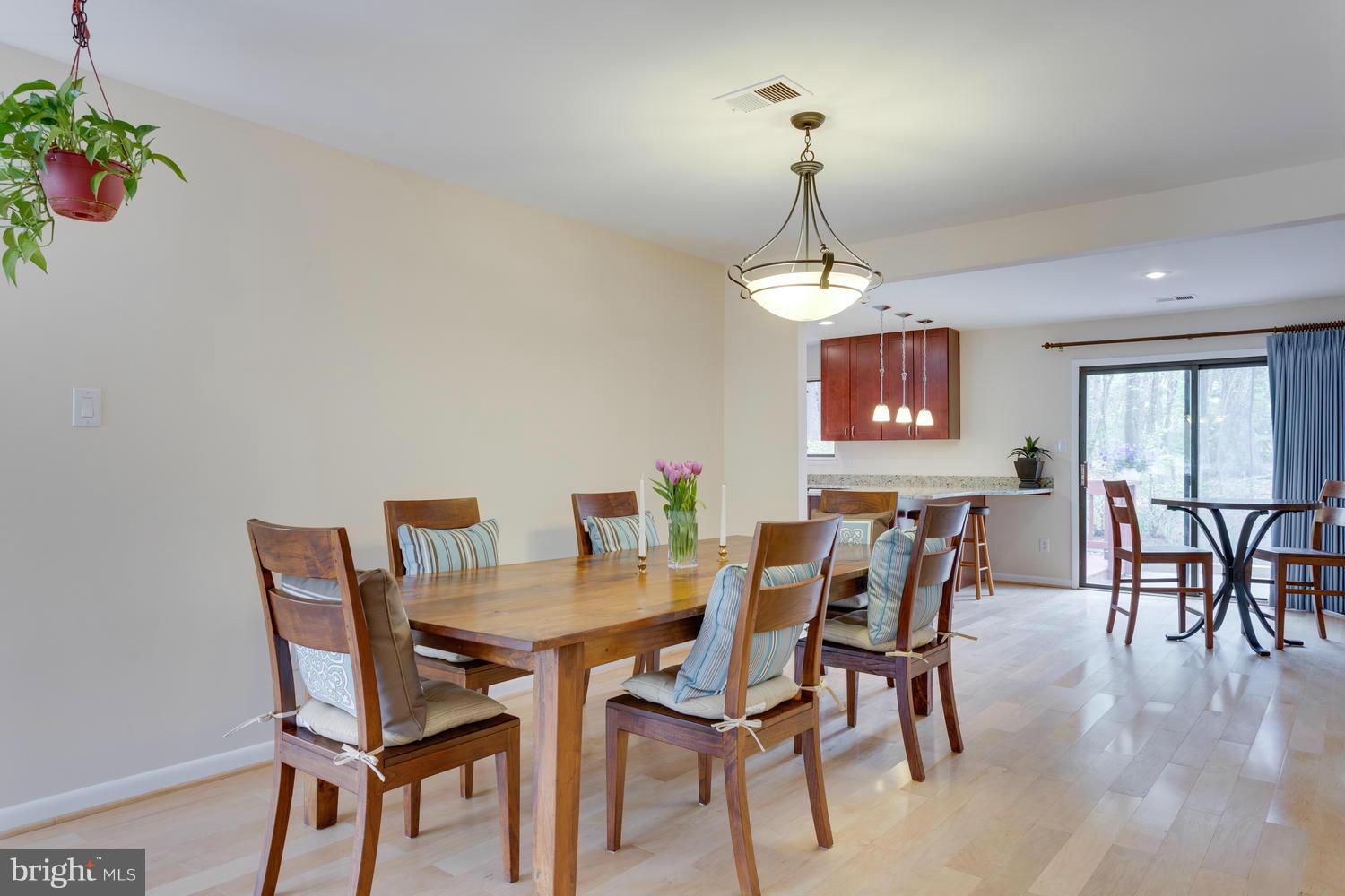 12348 Lima Lane Reston, VA 20191 - Photo 6 of 26 a dining room with furniture a chandelier and wooden floor
