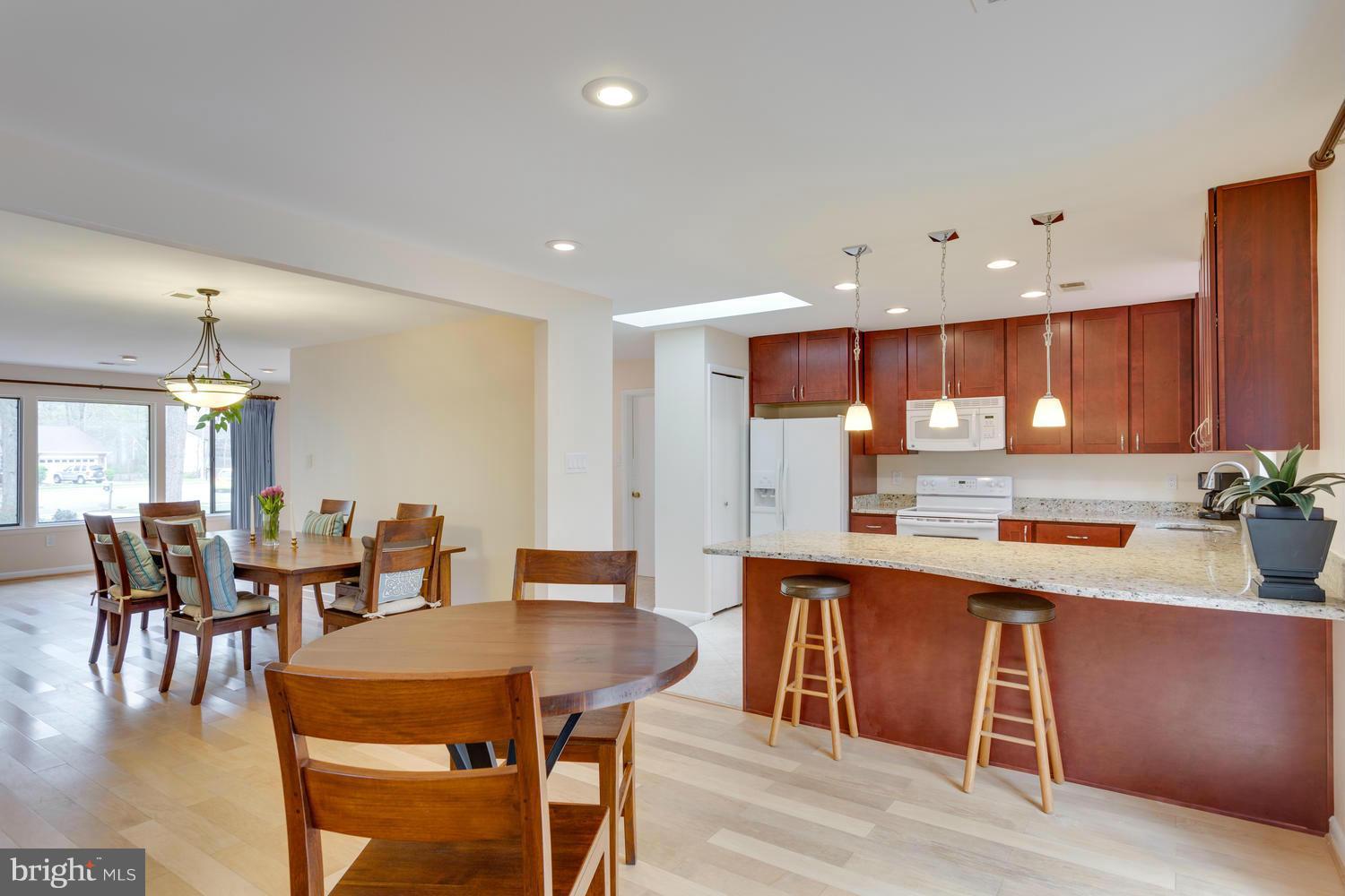 12348 Lima Lane Reston, VA 20191 - Photo 9 of 26 a dining hall with stainless steel appliances a dining table and chairs with wooden floor