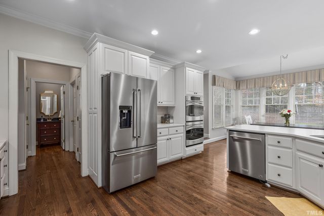 a kitchen with stainless steel appliances a refrigerator sink and wooden floor