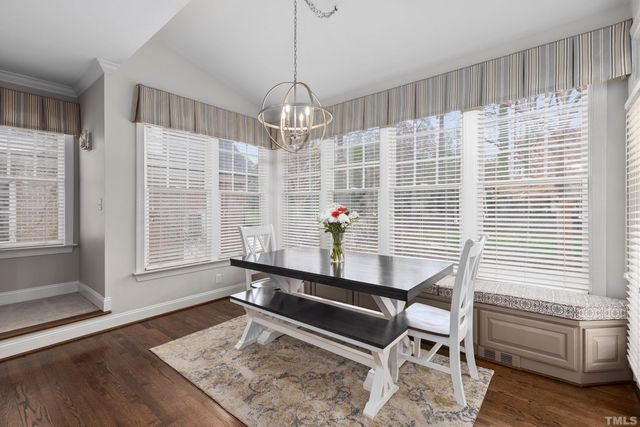 a dining room with wooden floor and a chandelier