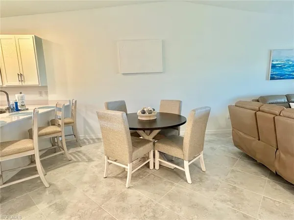 a dining hall with stainless steel appliances a dining table and chairs