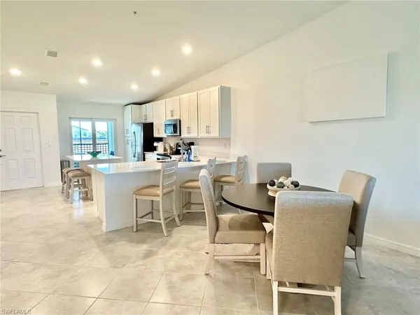 a bed sitting in a bedroom next to a window and a chandelier