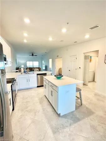 a large kitchen with stainless steel appliances lots of white cabinets