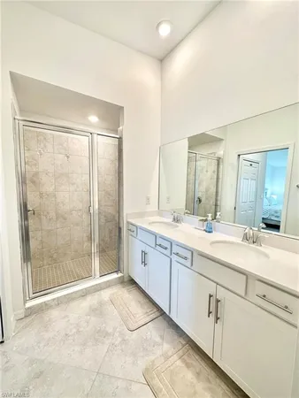 a spacious bathroom with a shower sink and mirror
