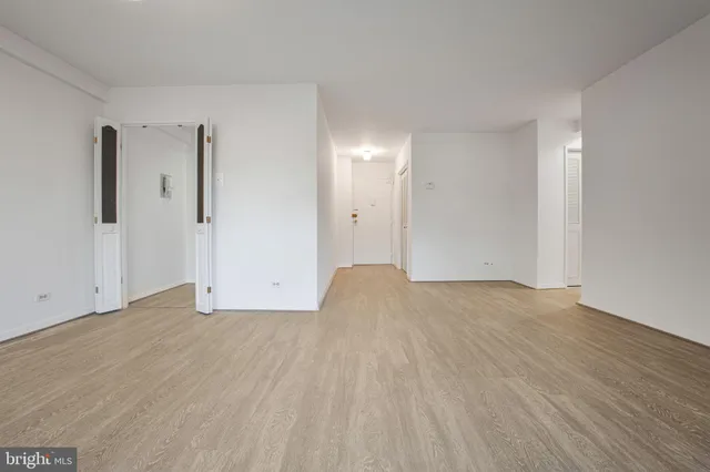 a view of empty room with wooden floor