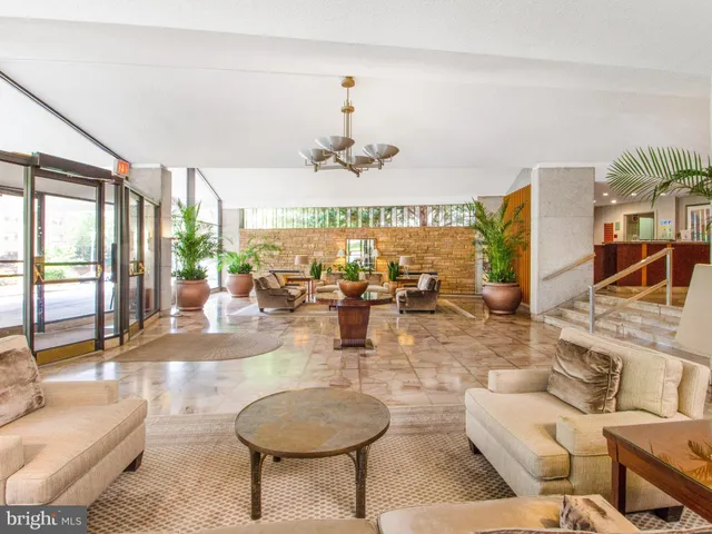 a room with lots of white furniture and a large window