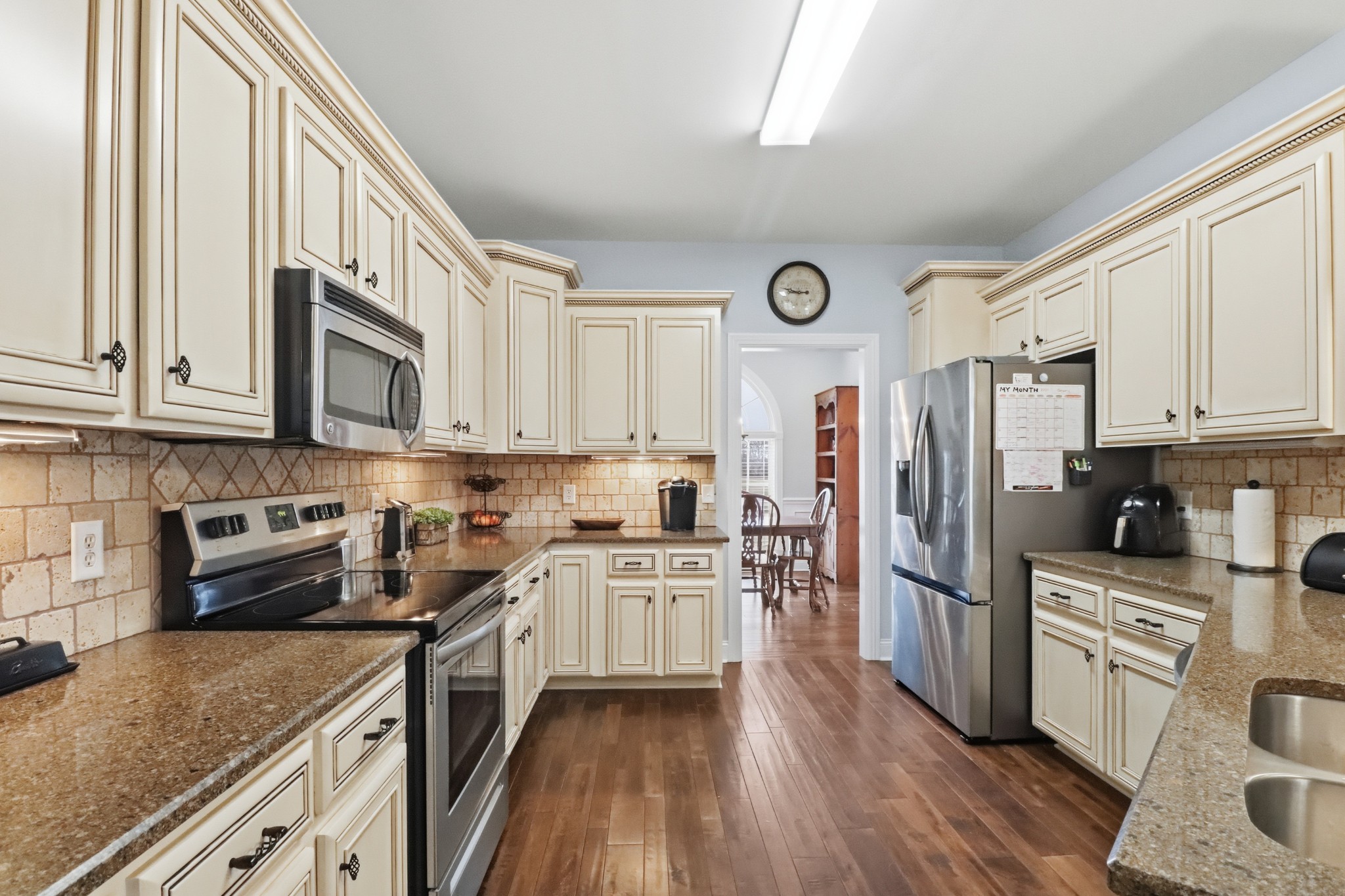3287 Bluebird Road Lebanon, TN 37087 - Photo 9 of 64 a kitchen with stainless steel appliances granite countertop a stove top oven a refrigerator a sink and dishwasher with white cabinets