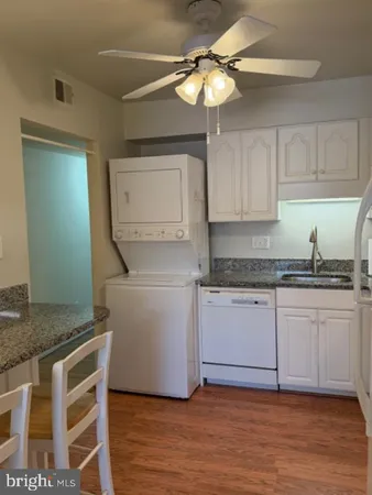 a kitchen with a sink cabinets and wooden floor