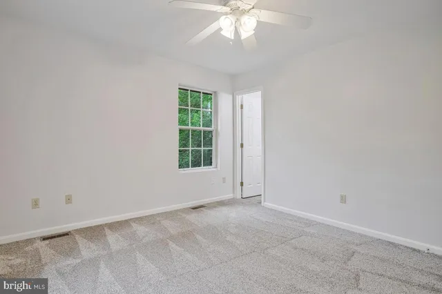 an empty room with chandelier fan