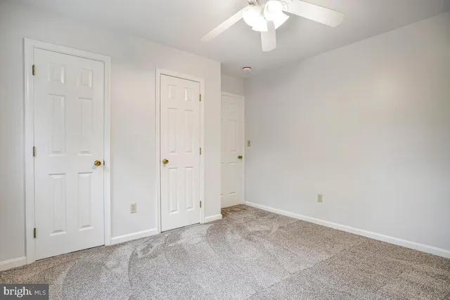 an empty room with a chandelier fan