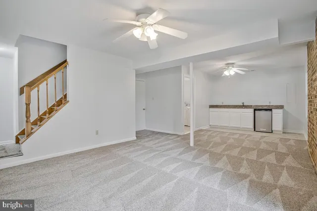 a view of an empty room with a chandelier fan