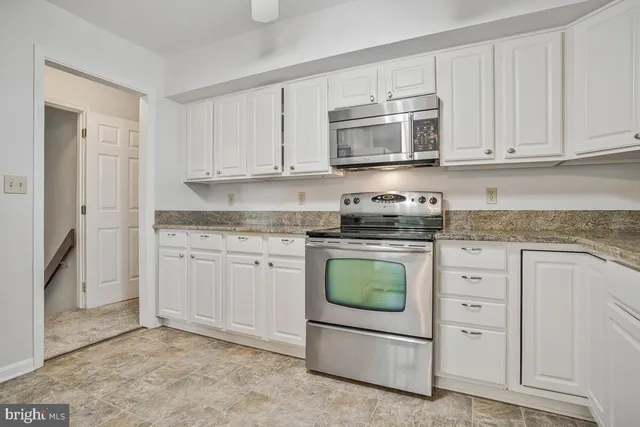 a kitchen with white cabinets and white appliances