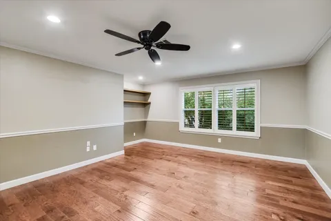 a view of an empty room with a window and wooden floor