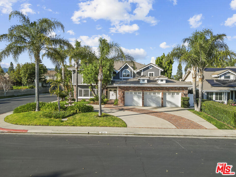 18779 Willowtree Lane Porter Ranch, CA 91326 - Photo 1 of 63 a front view of a house with a garden and a yard