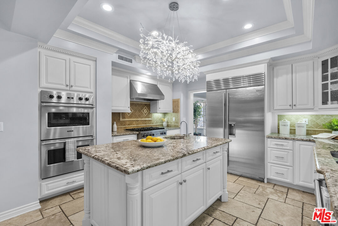 18779 Willowtree Lane Porter Ranch, CA 91326 - Photo 17 of 63 a kitchen with stainless steel appliances granite countertop a sink stove and refrigerator