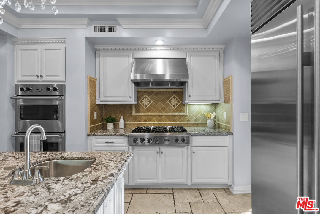 18779 Willowtree Lane Porter Ranch, CA 91326 - Photo 18 of 63 a kitchen with granite countertop a stove and a sink